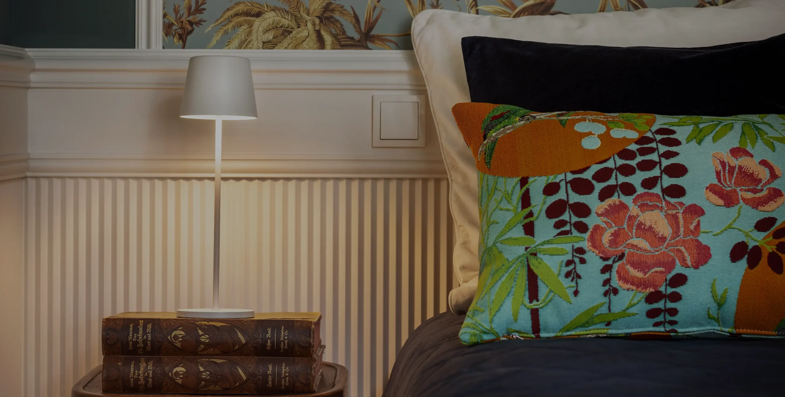 Ein Bett mit einer Lampe und Kissen.